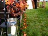 rustic fall wedding aisle with bright leaves, twigs and hanging candle lanterns is a cool rustic idea for the fall
