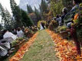 a simple and bright fall wedding aisle decorated with bold fall leaves is a cool idea you can DIY
