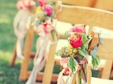 a bold fall wedding aisle arrangement of pink and yellow roses, greenery and pink ribbons is a lovely idea for the fall