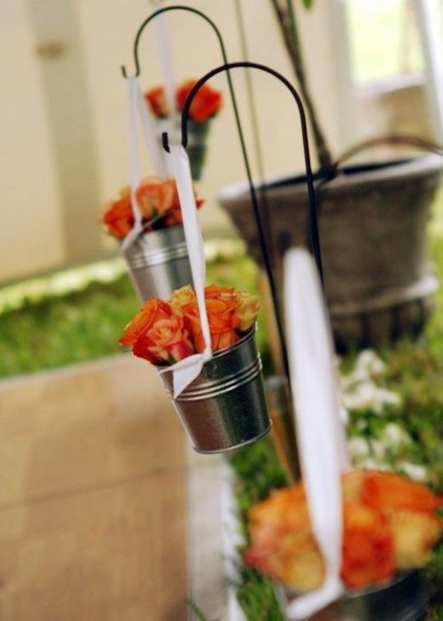 hanging buckets with bright orange roses are amazing to line up the aisle and make it bolder and cooler