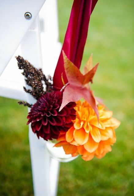 a bold fall floral arrangement with an orange and burgundy bloom and some leaves is a pretty idea for a fall wedding