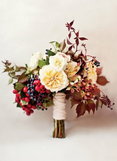 a beautiful fall wedding bouquet of neutral blooms, bold berries, greenery and bright dried leaves is great for a fall wedding