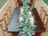 lush eucalyptus table runners and white candles in simple candle holders – and you won’t need more for a gorgeous tablescape