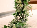 a super lush greenery table runner with white and green blooms looks very chic and textural