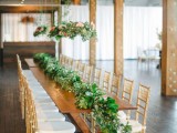 a luxurious greenery table runner with lots of succulents and air plants plus hanging centerpieces over the table
