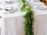 a delicate and airy foliage table runner with candles for more elegance and a refined touch