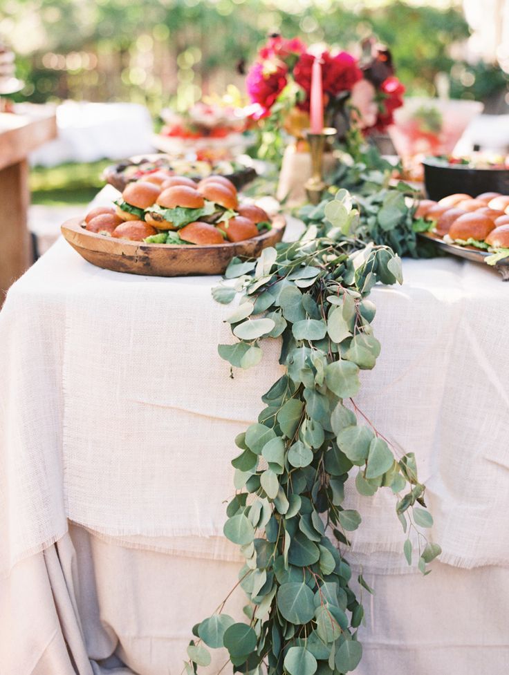 A eucalyptus table runner over a white tablecloth is a chic and timeless idea