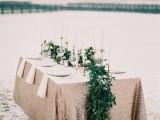 a lush greenery table runner over a copper sequin table runner is a very bold idea