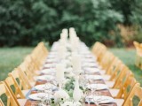 a fern, foliage and white bloom table runner with candles is a chic and bold idea