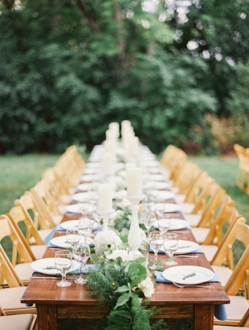a fern, foliage and white bloom table runner with candles is a chic and bold idea