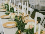a lush greenery plus white and blush blooms and candles in gilded candle holders for a refined look