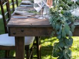 a lush eucalyptus table runner and touches of greenery for each place setting