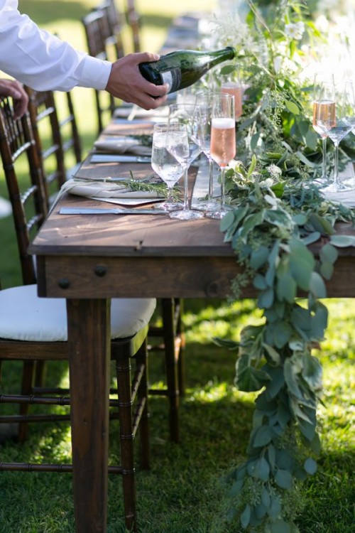 a lush eucalyptus table runner and touches of greenery for each place setting