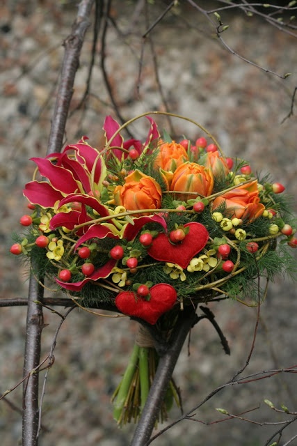 a bold Valentine wedding bouquet of burgundy, yellow blooms, berries, greenery and bold red fabric blooms is a bright idea