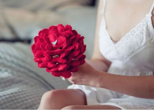 a non-typical wedding bouquet composed of red felt hearts and with a littel bird is a chic and creative idea for a Valentine bride