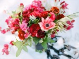 a pink, red, burgundy wedding bouquet with greenery is a bold and chic statement for a Valentine bride
