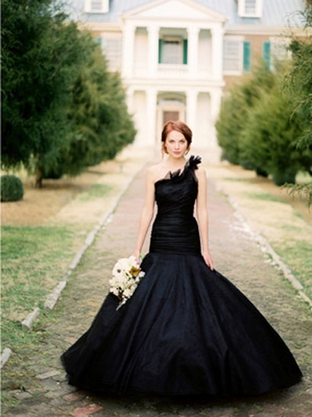 a black mermaid one shoulder wedding dress with a draped bodice, ruffles on the shoulder and a full skirt for a sophisticated wedding