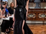 a unique sculptural black strapless wedding dress with a pleated bodice and a skirt with a slit, a train and a wide belt is amazing