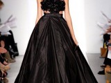 a stunning black wedding dress with a shiny pleated full skirt and an embellished crop bodice plus a black velvet strap is wow