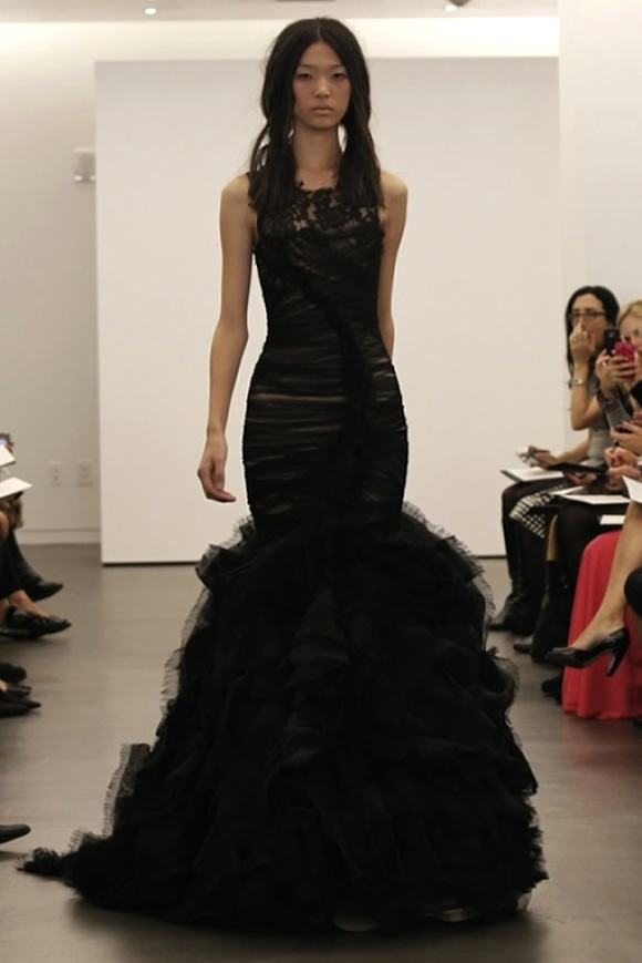A mermaid black wedding dress with a tail, a lace sleeveless bodice, a train is a lovely idea for a bold Halloween wedding