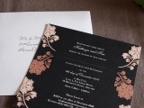 a black wedding invitation with gold and copper fall leaves printed on it for a chic and contrasting look