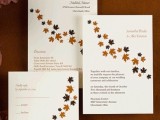 a fall wedding invitation suite with burgundy and rust-colored leaves decorating each piece
