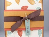 a bold fall wedding invitation with bright fall leaves and ties and a tag for the fall