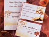 a bright fall wedding invitation suite with fall leaves, branches and trees plus a sign printed on it