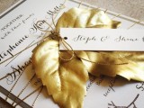 a glam fall wedding invitation suite in a monochromatic color scheme, glitter twine and a gold fall leaf on top