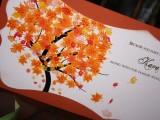 a bold fall wedding invitation with a fall tree and bright fall leaves printed for a bright and unique look