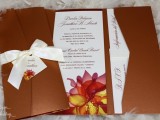a bold fall wedding invitation suite on chocolate brown with bright fall blooms printed and a creamy bow