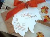 fall wedding invitations shaped as leaves and with an orange bow on top