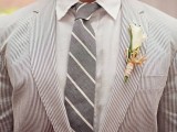a striped outfit with a thin stripe grey suit, a white shirt and a striped grey tie
