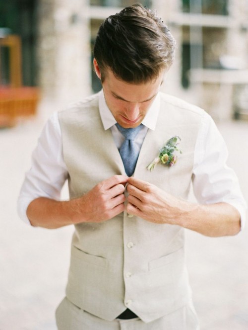 a simple neutral groom's outfit with a tan waistcoat, a blue tie and a white shirt