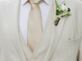 a neutral and formal groom’s look with three pieces, a neutral tie and a white shirt for a more formal summer wedding