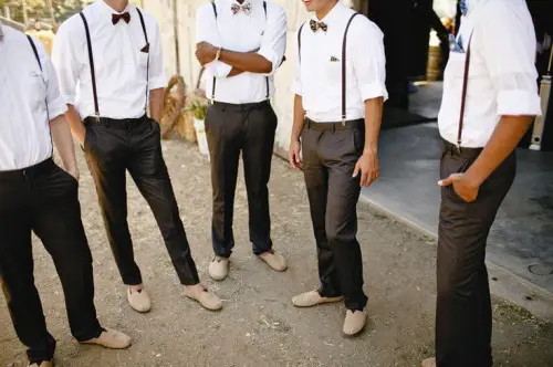 a groom and groomsmen wearing pants, shirts, suspenders and bow ties not to oversweat on a hot day