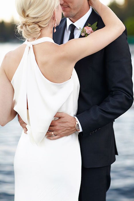 a minimalist white sheath wedding dress with a halter nekcline, and a cutout back