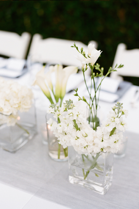 minimalist wedding centerpieces of white blooms placed into simple sheer vases