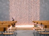 a minimalist wedding backdrop of a wall of lights is a chic idea for a minimalist or modern wedding