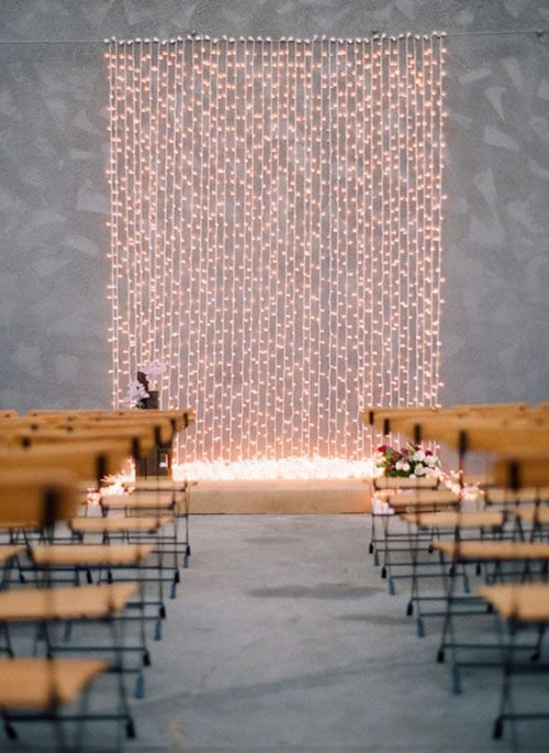 a minimalist wedding backdrop of a wall of lights is a chic idea for a minimalist or modern wedding