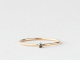 a minimalist wedding band in gold with a single black diamond is a chic idea