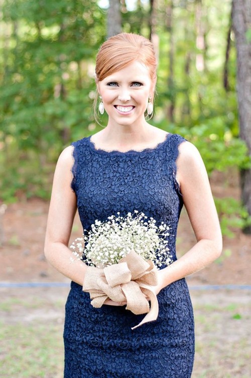 a navy lace sheath bridesmaid dress and a baby's breath bouquet plus rhinestone earrings
