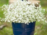 a navy bucket with baby’s breath is a cool rustic decoration for a wedding