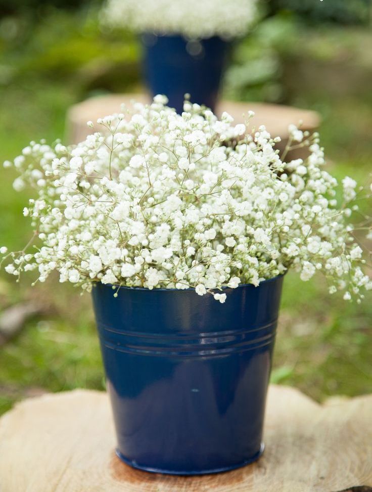 A navy bucket with baby's breath is a cool rustic decoration for a wedding
