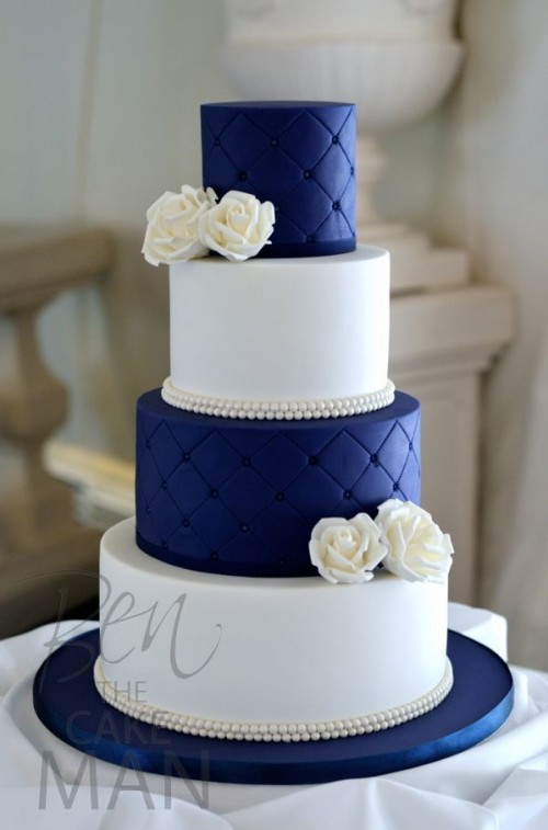 a navy and white wedding cake with plain and textural tiers and white white blooms for a refined wedding