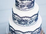 a refined wedding cake in white decorated with navy lace is a great idea to continue your wedding color scheme