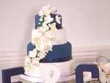 a chic navy and white wedding cake decorated with white sugar blooms is a lovely and bold idea for a refined wedding