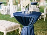 a navy tablecloth paired with a white floral centerpiece create a bold combo and look for the lounge
