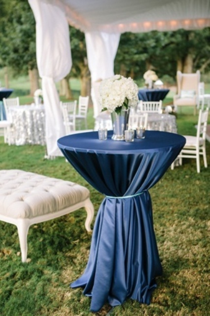 a navy tablecloth paired with a white floral centerpiece create a bold combo and look for the lounge