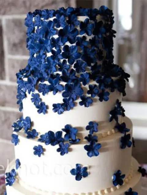 a white wedding cake with navy sugar flowers is a fantastic dessert that will keep your wedding color scheme up